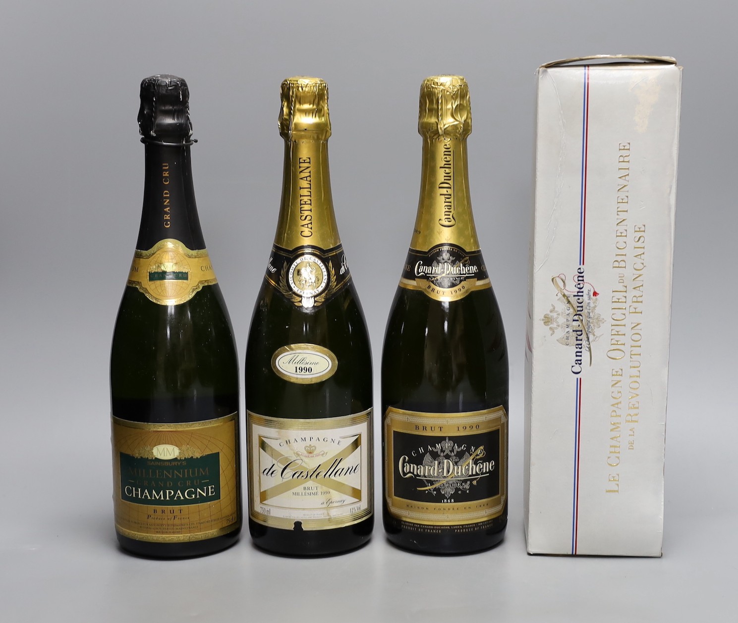 A bottle of 1990 Canard-Duchene champagne, a bottle of Castellane champagne, 1990, a millennium champagne and a boxed bottle of Canard Duchene for the bicentennial of the French Revolution